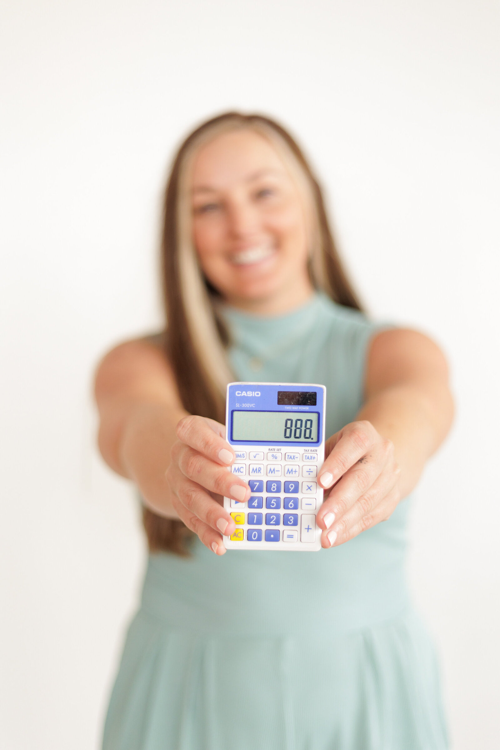 Lifestyle branding image of woman accountant holding a calculator during content shoot in Portland Oregon.