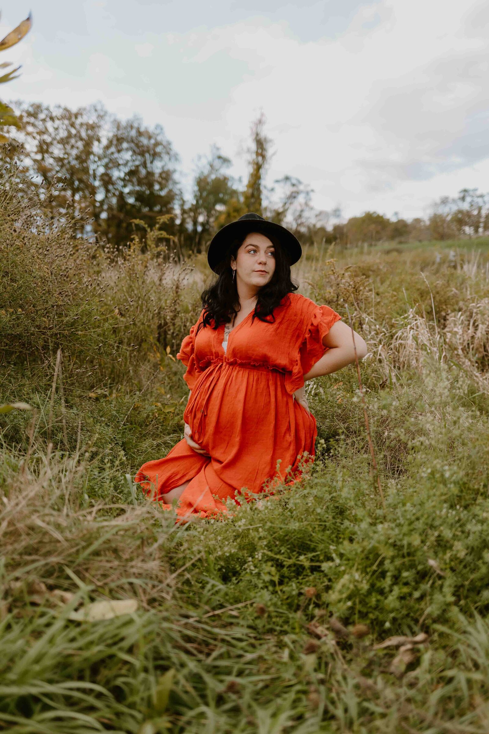 pregnant mom sitting in grass during maternity photoshoot