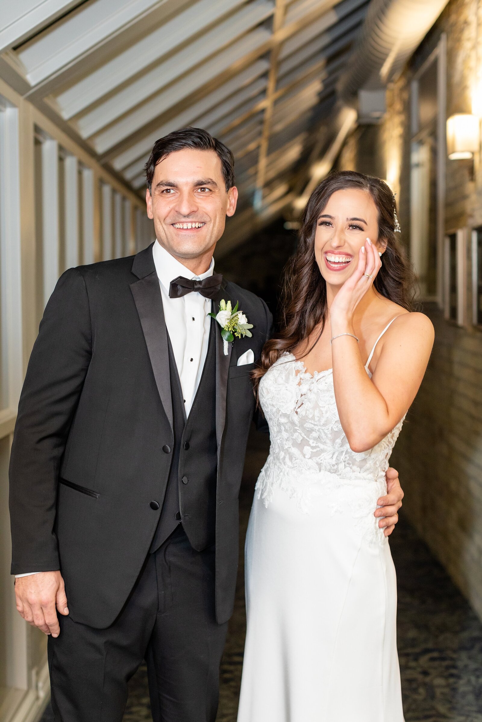 Bride-and-groom-laughing-together-in-the-halls-of-delta-armouries-in-london-ontario