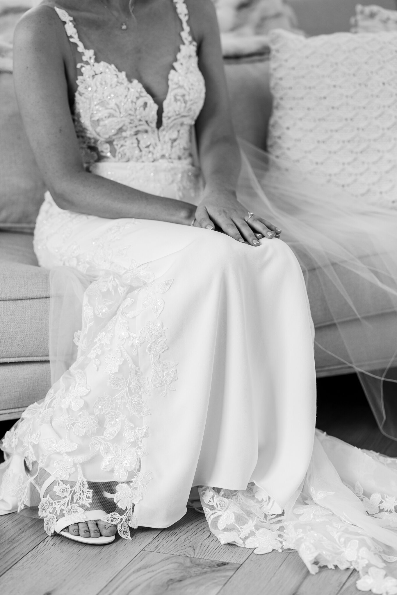 Elegant close-up of bride’s hands resting on lace wedding gown at SkyView Golf Club