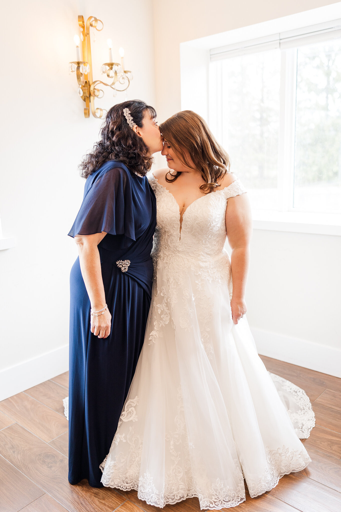 Emotional moment of the bride’s mom kissing her on the forehead before the ceremony at Perona Farms