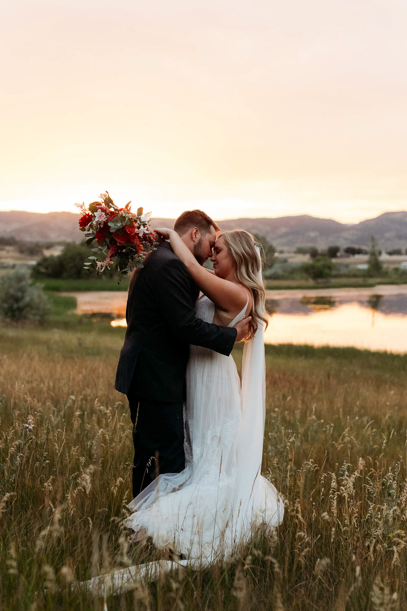 serious photo of bride and groom alone together in a field on the waters edge