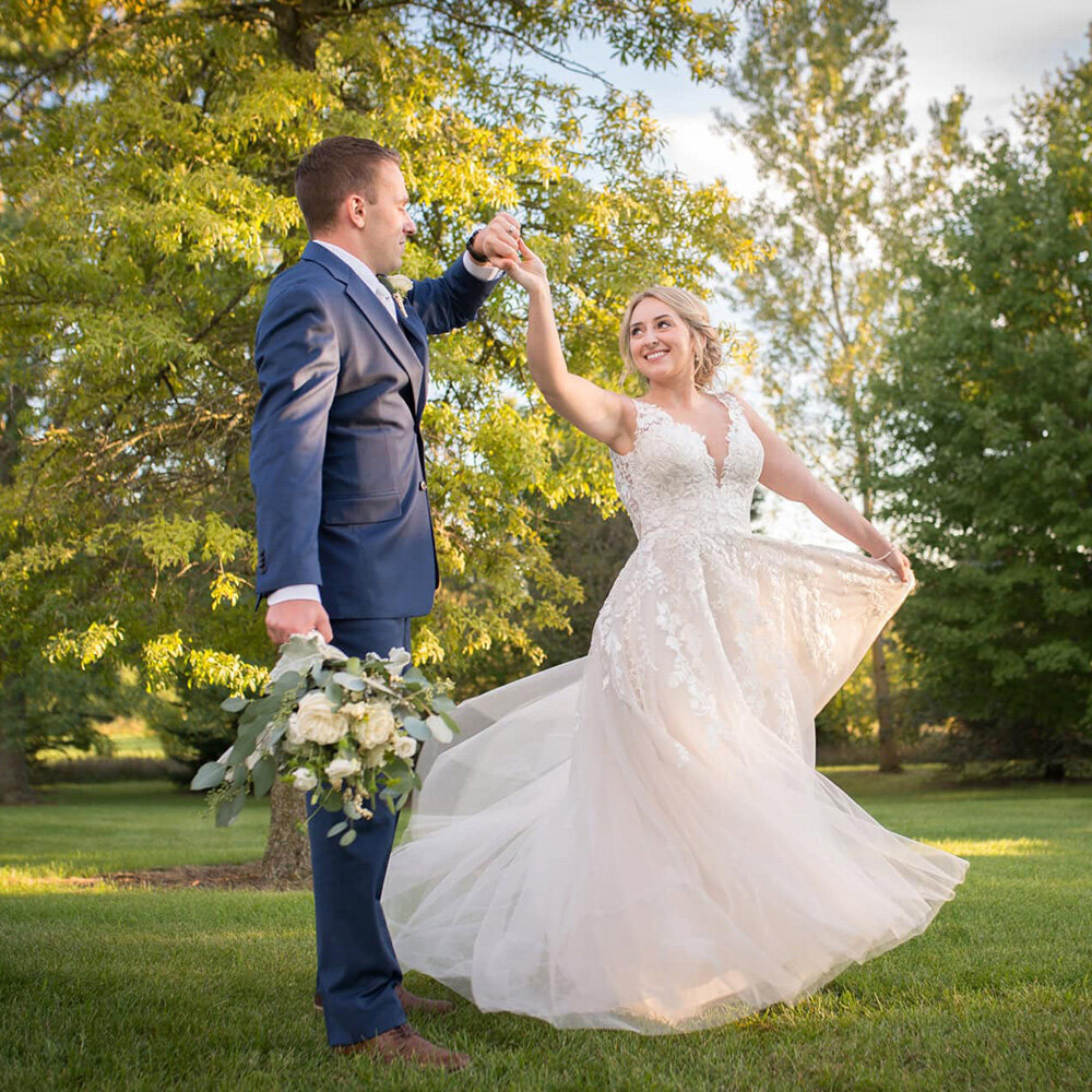 groom twirls bride in backyard