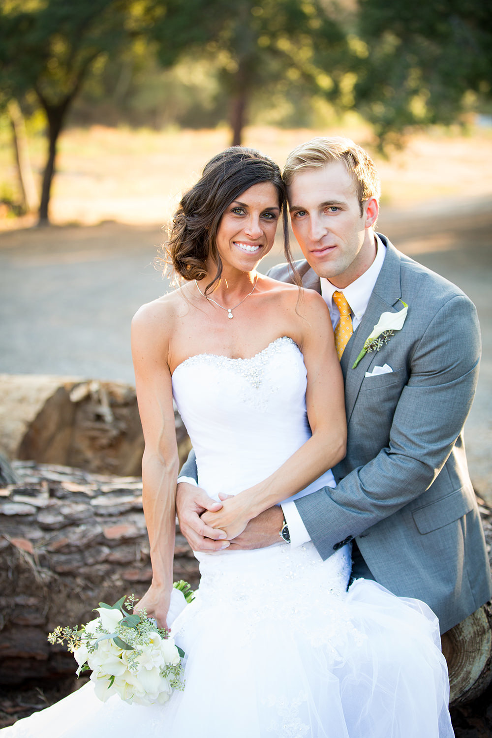 bride and groom smiling with lake in the background