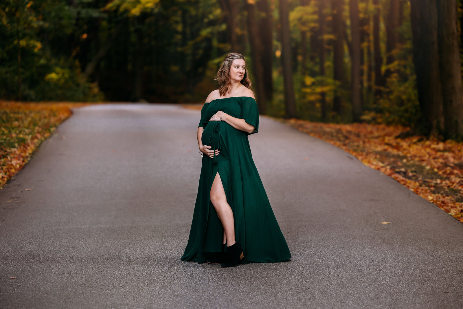 Beautiful mom-to-be cradling her baby bump during a maternity photo session
