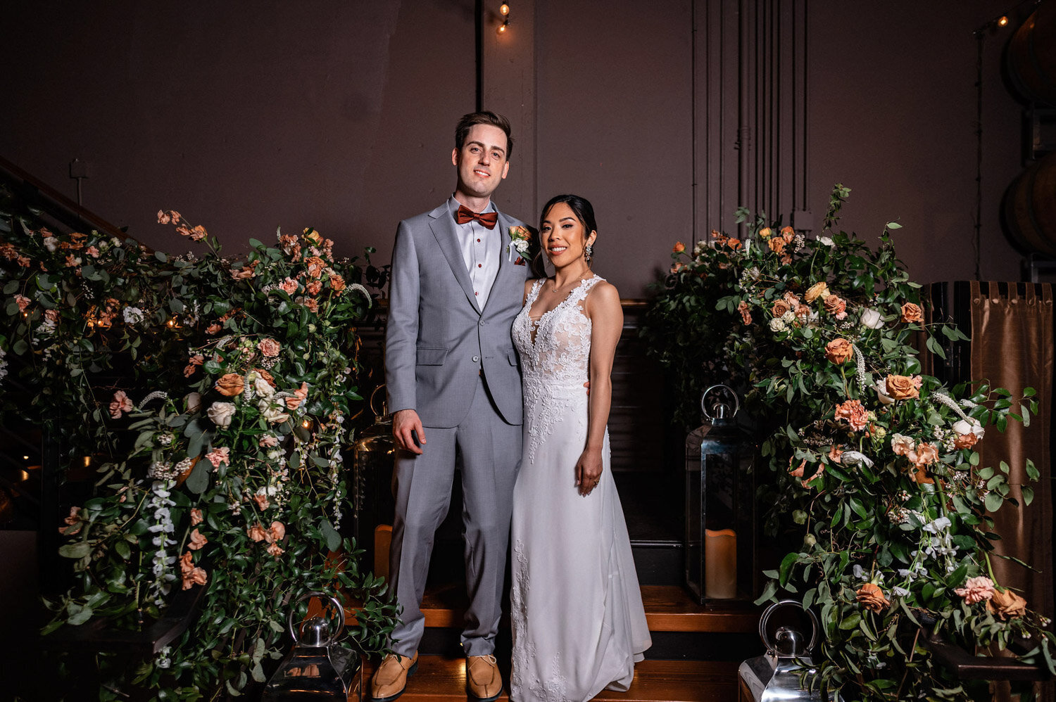 Bride and groom standing together with floral aisle decor