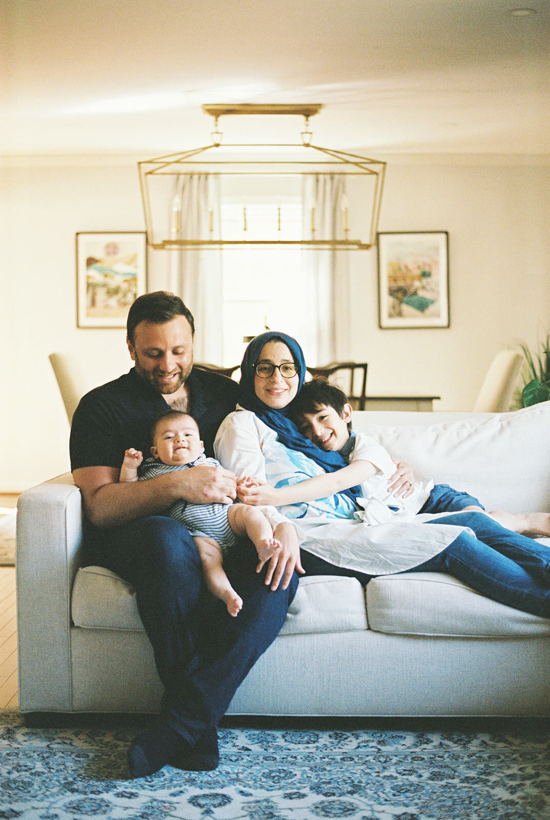 Lifestyle photo of a family sitting together on a bright, modern couch with a cozy atmosphere.