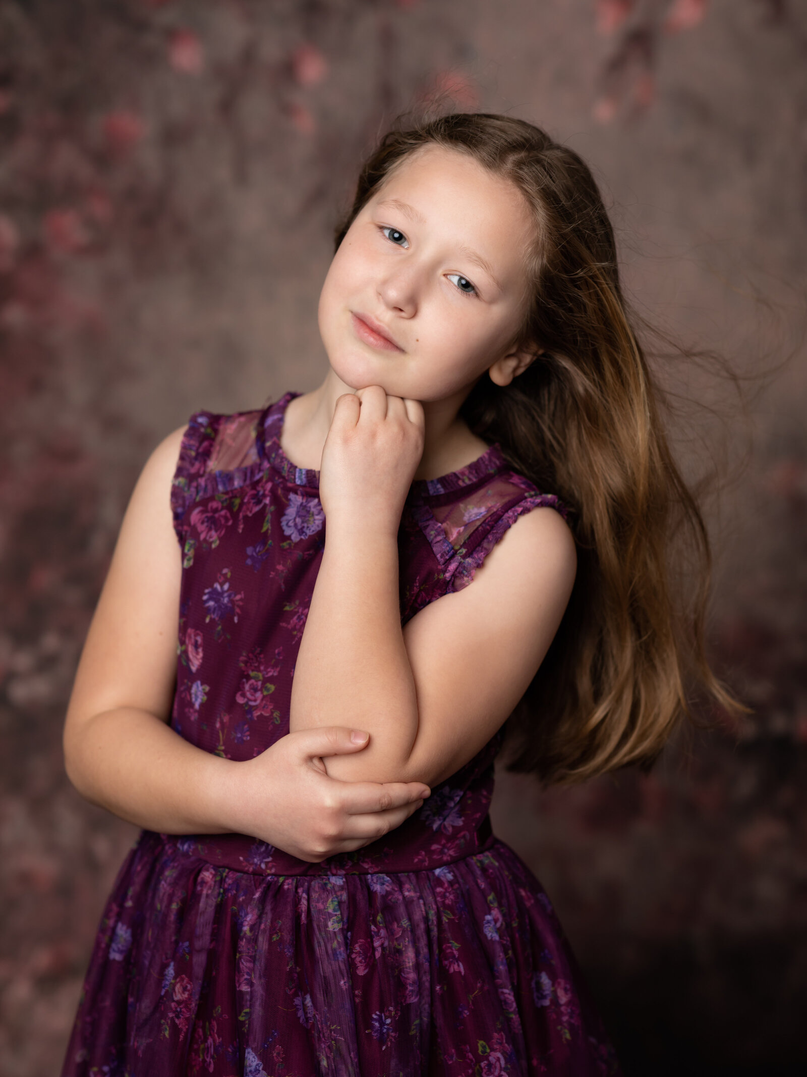 girl in purple dress with floral backdrop for studio birthday photoshoot