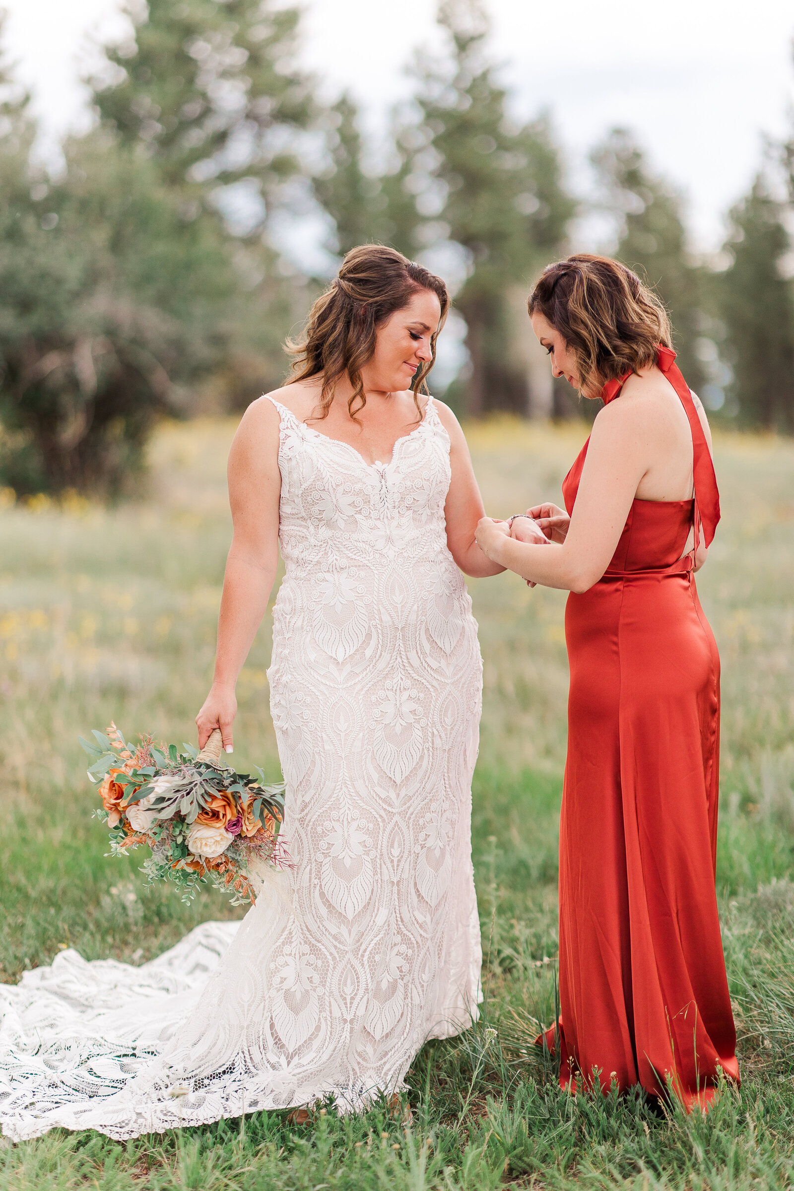 maid of honor helping bride with bracelet
