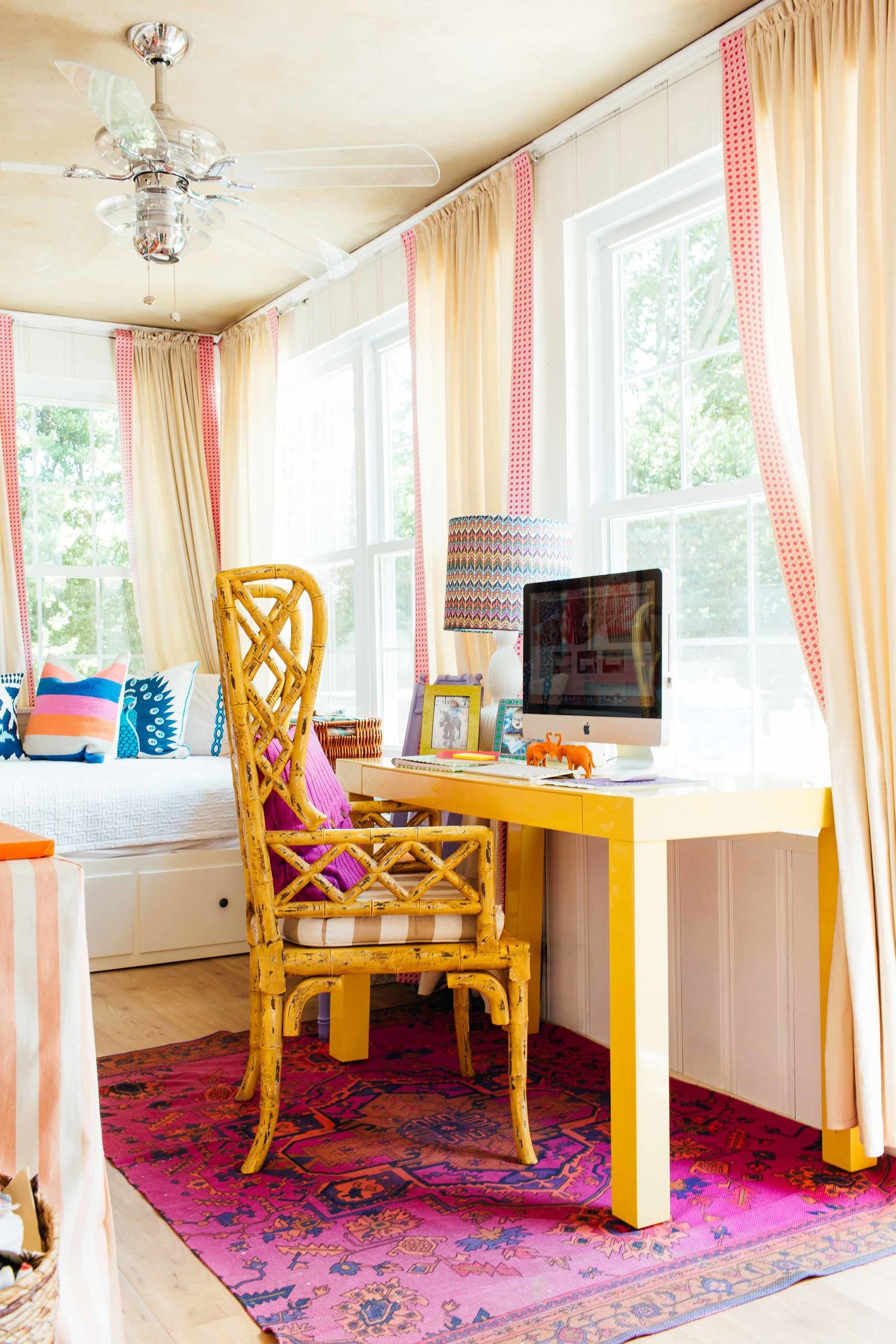 A colorful  interior design studio with day bed and yellow computer desk.
