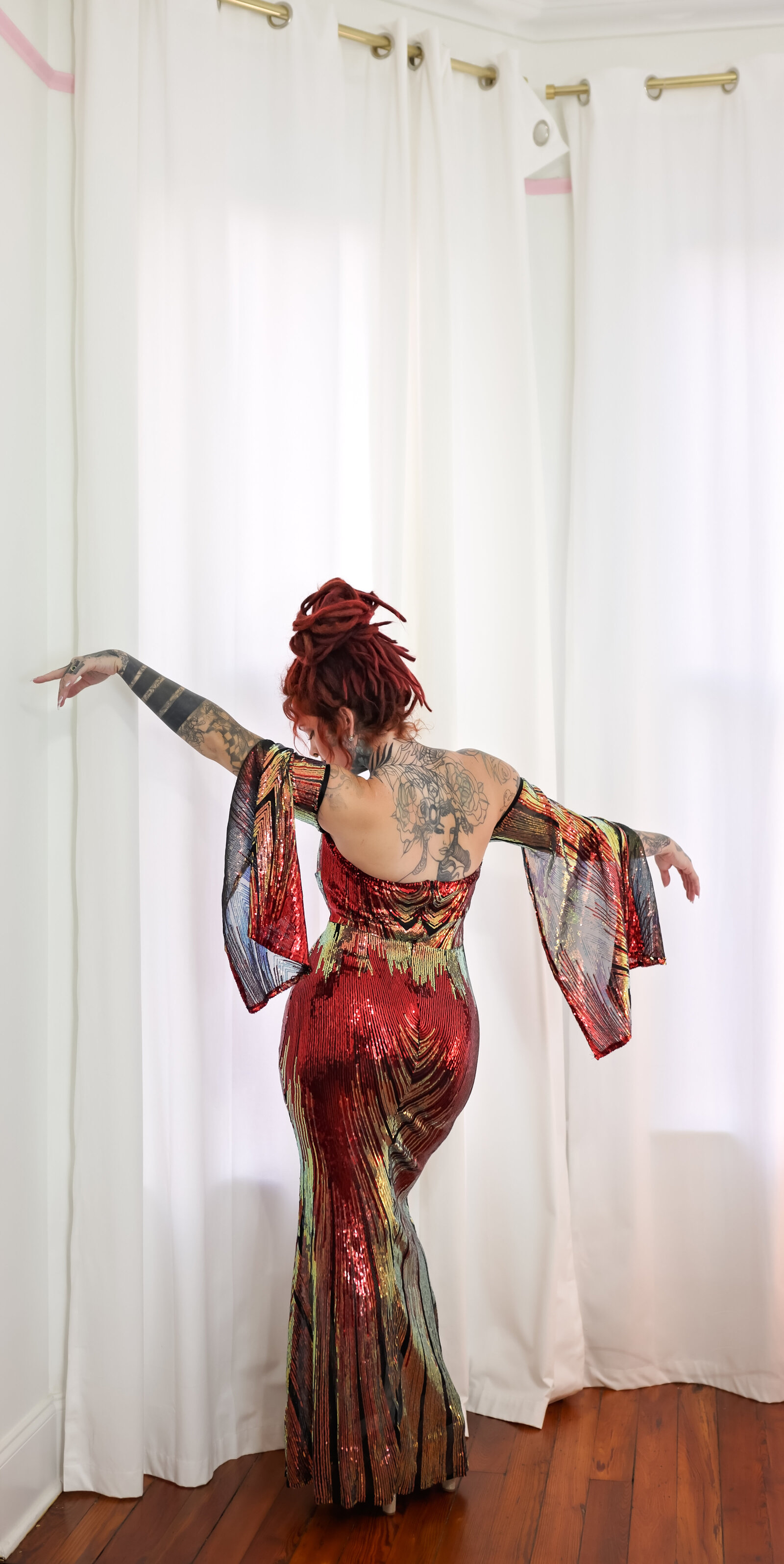 Savannah Boudoir Photography and Glamour showcases gorgeous red headed woman with dreads in colorful and sparkly designer glamour gown