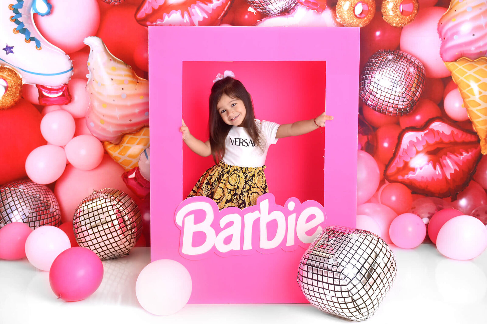girl smiles at her barbie themed birthday photoshoot in houston