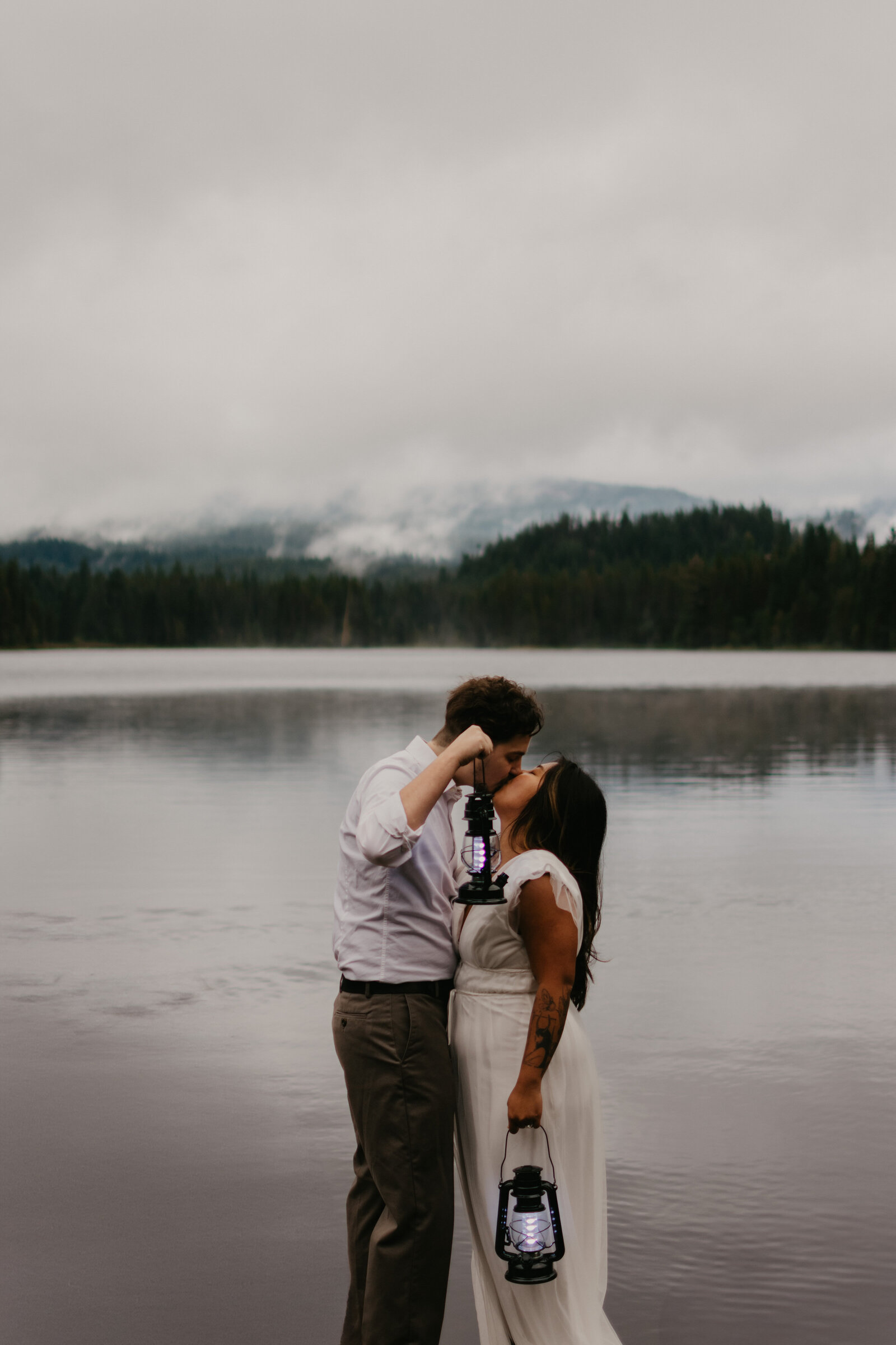 Couple standing on a rock kissing, with the background.