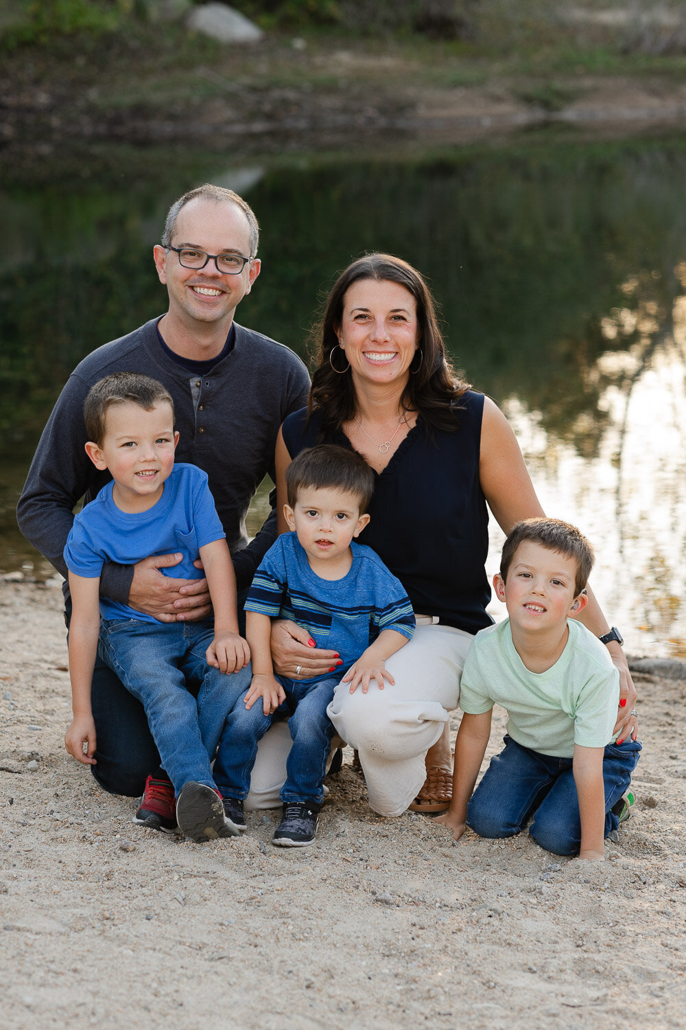 family sitting on sand
