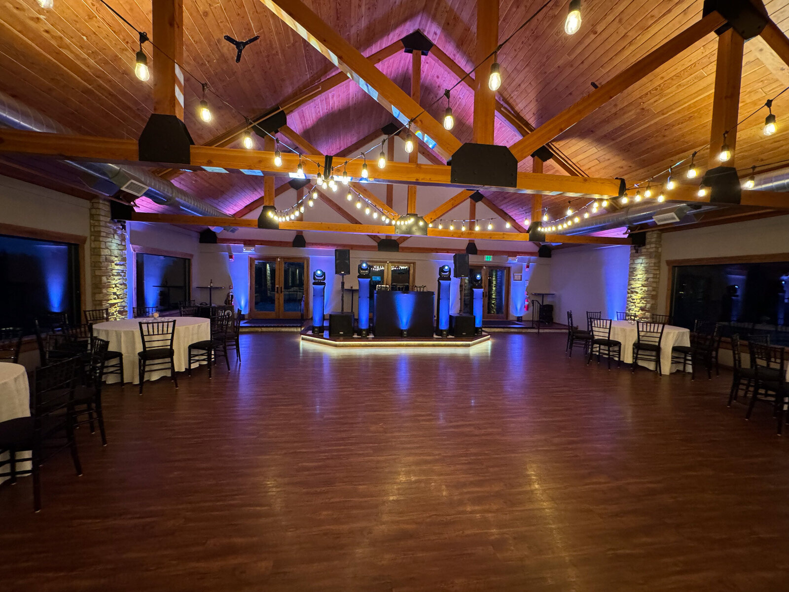 Empty dance floor with DJ setup and string lights