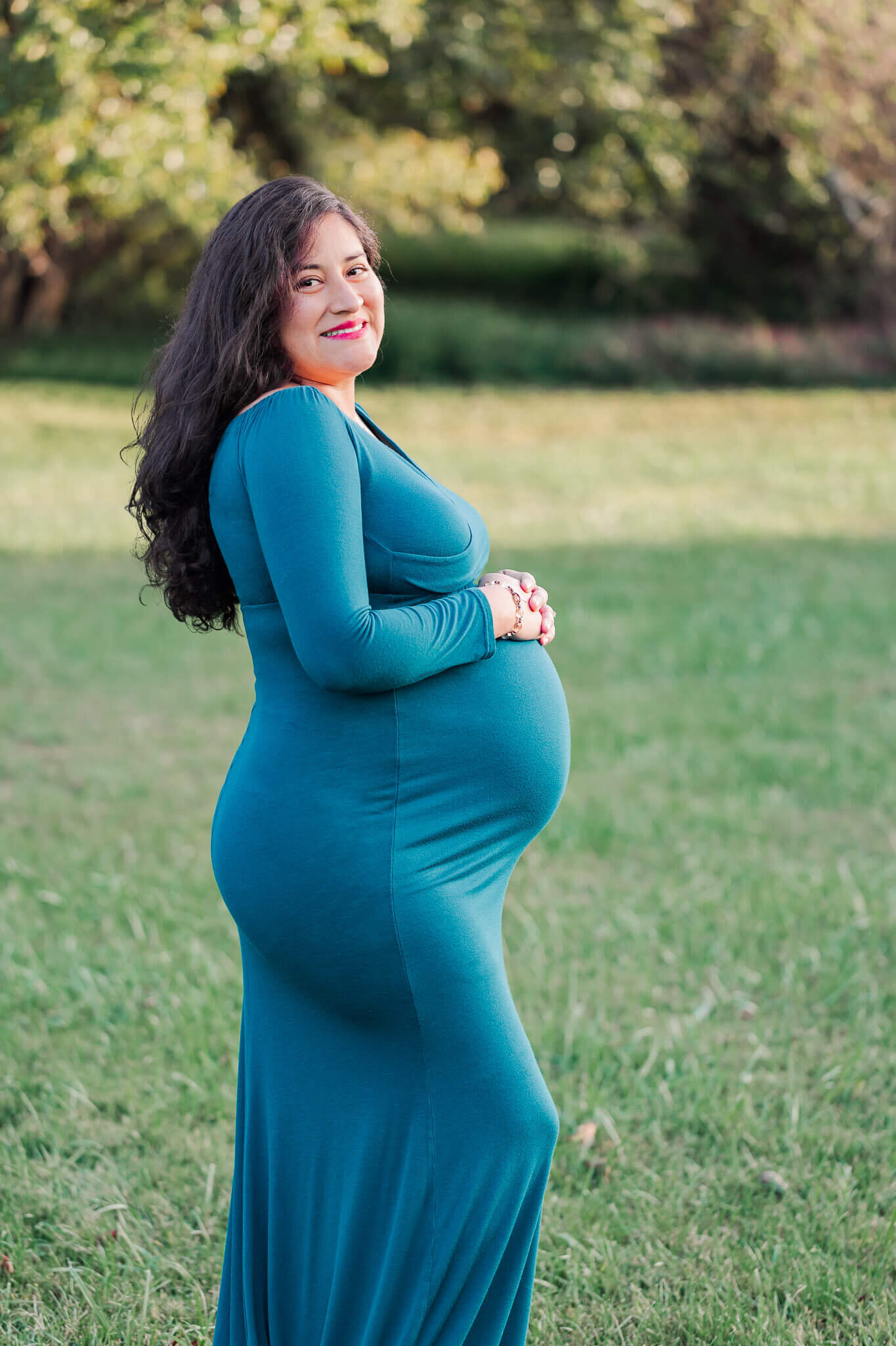 An expecting mother wearing a blue dress for her Burke maternity session.