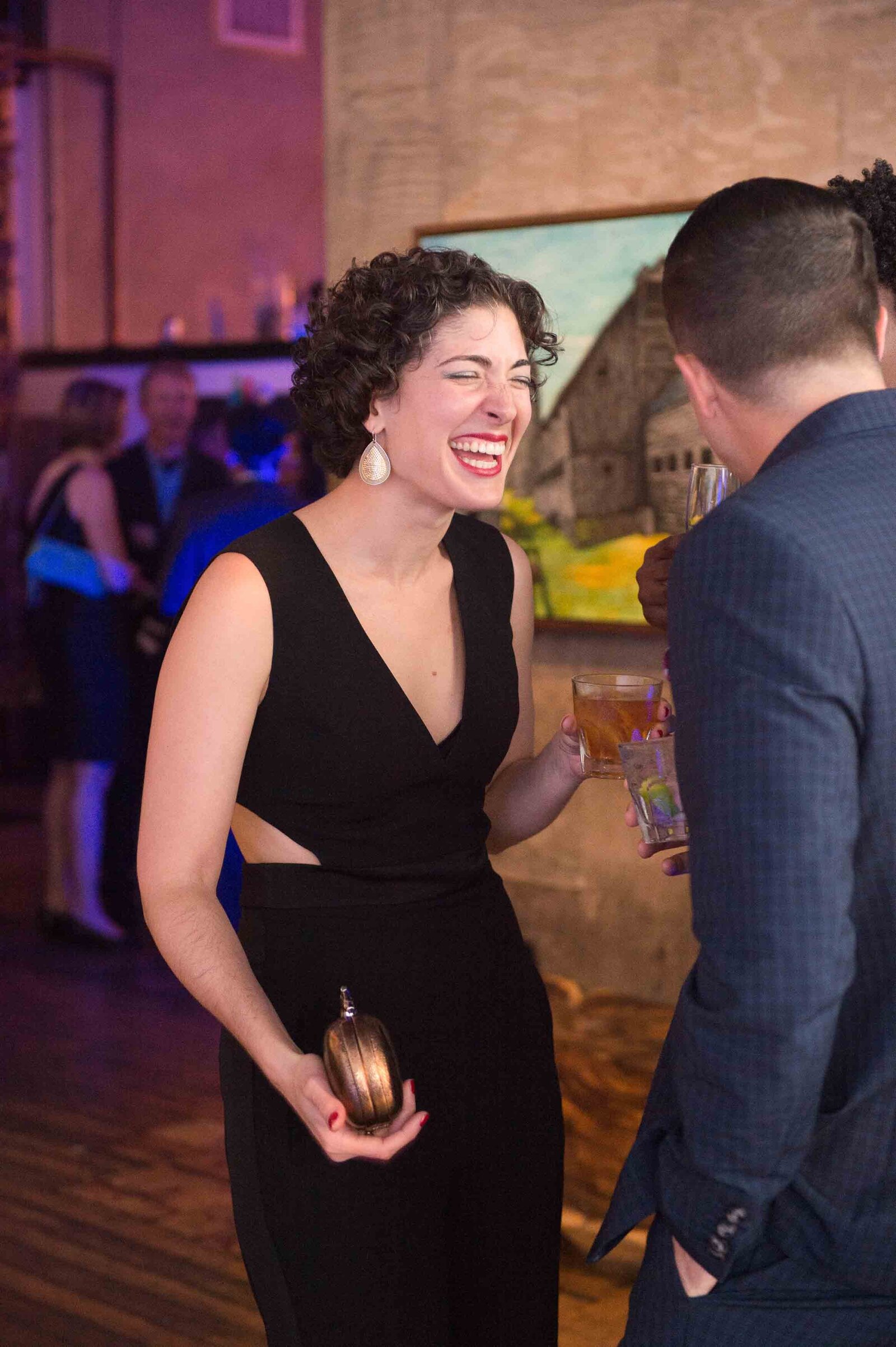 Holiday party woman laughing in conversation.-