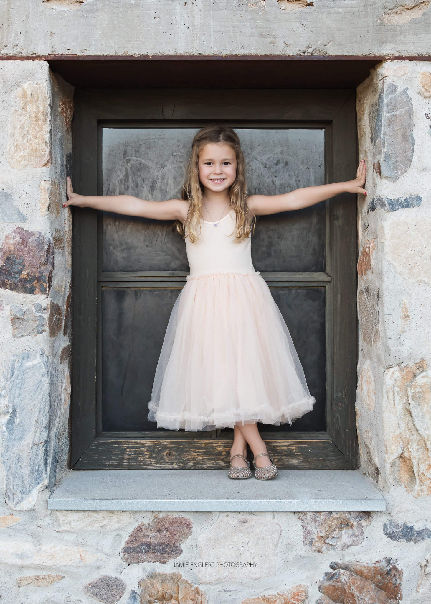 little girl standing in window, smiling
