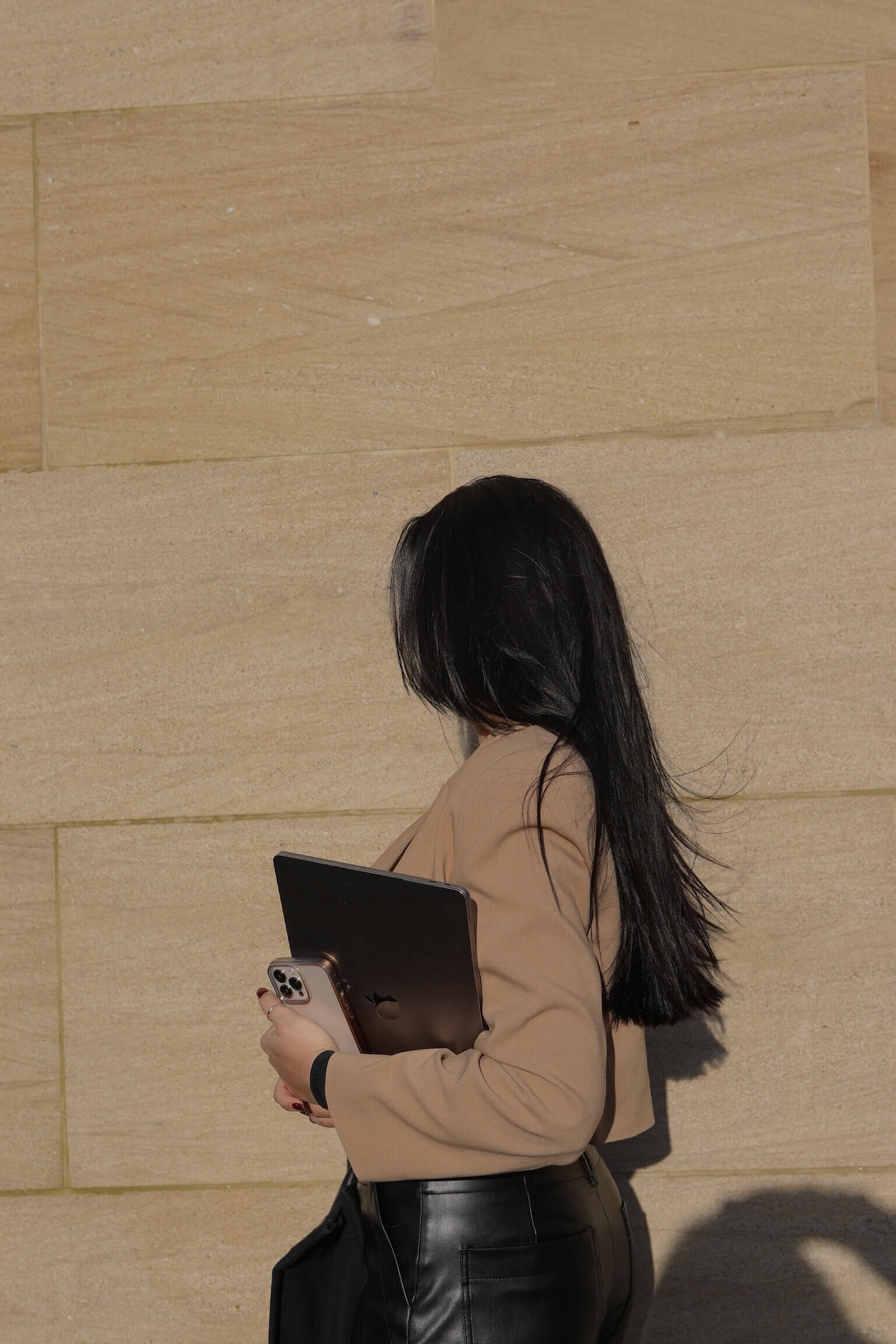 dark brunette girl holding her phone and laptop