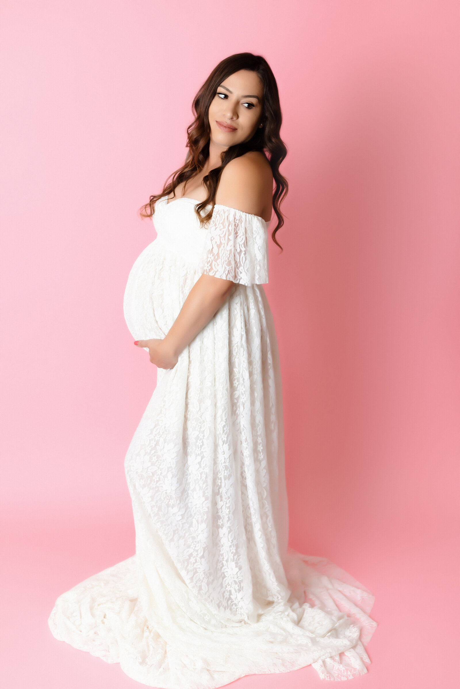Maternity Photographer, a woman wears a white maternity dress