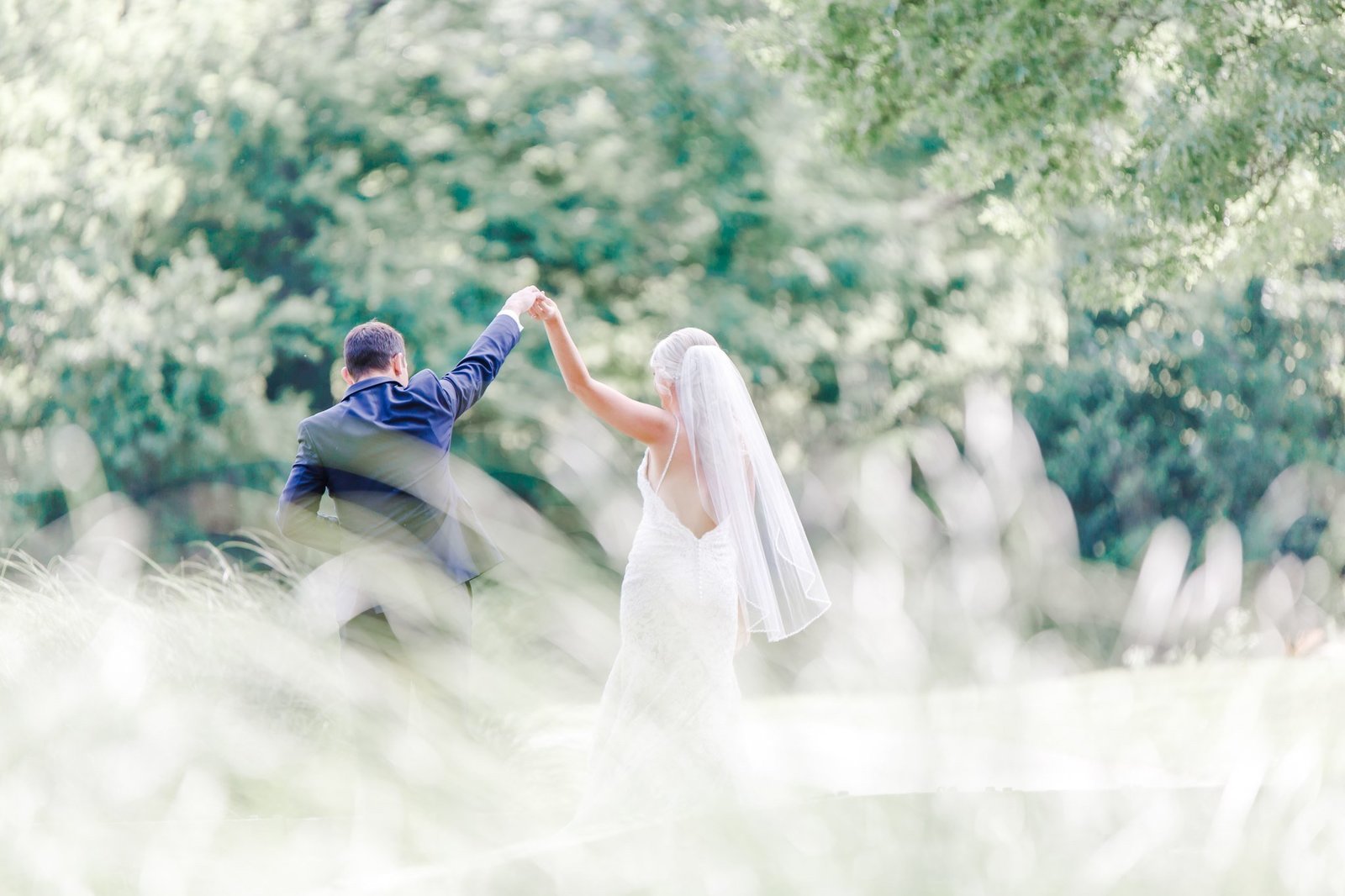 Groom twirling bride during first look to get a full view of her dress