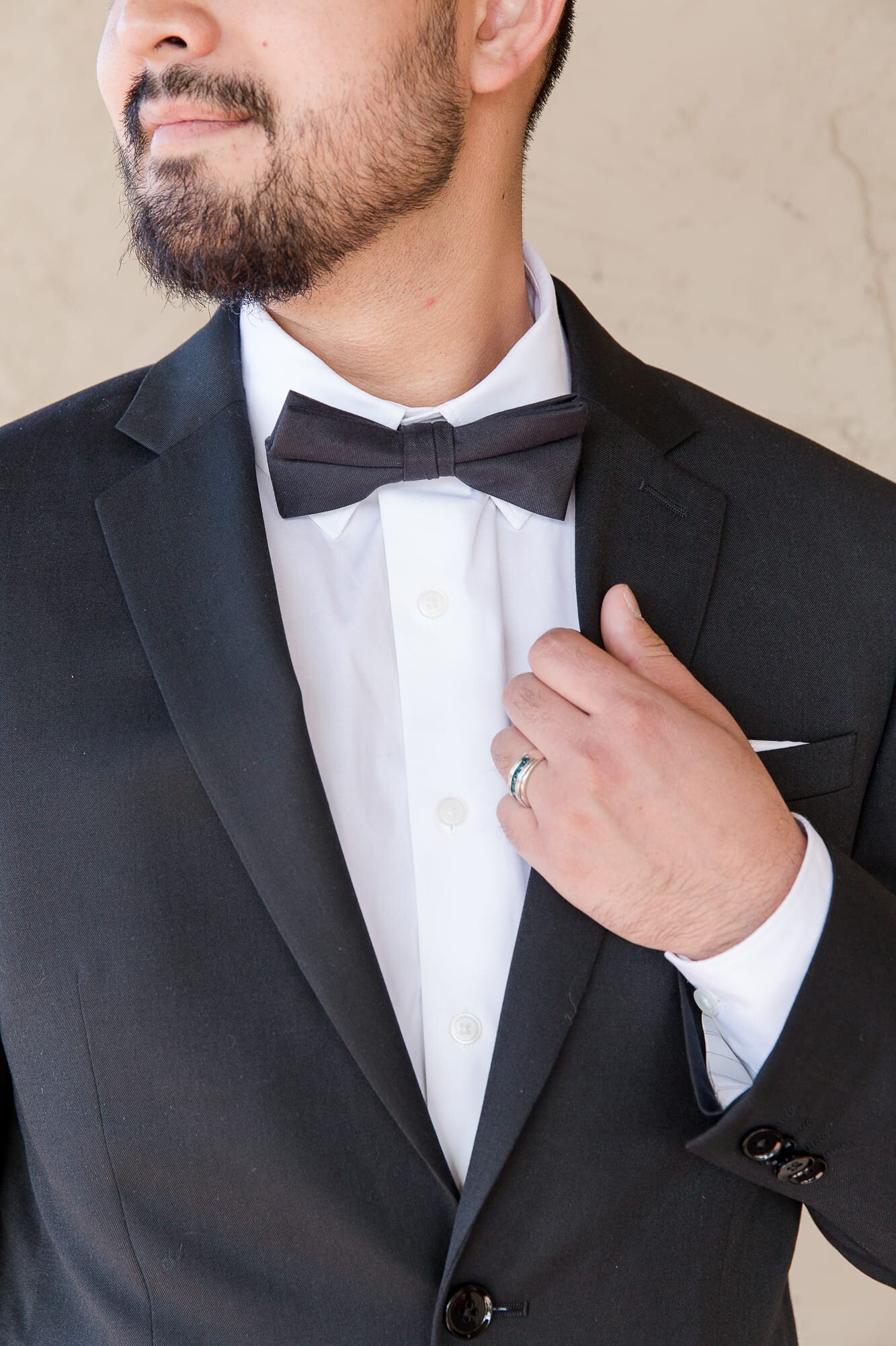 groom-holding suit-with-bow-tie