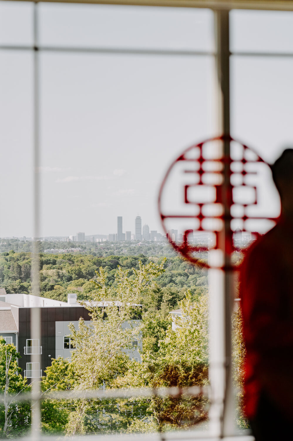 View of the city skyline through a window with red decor in the foreground