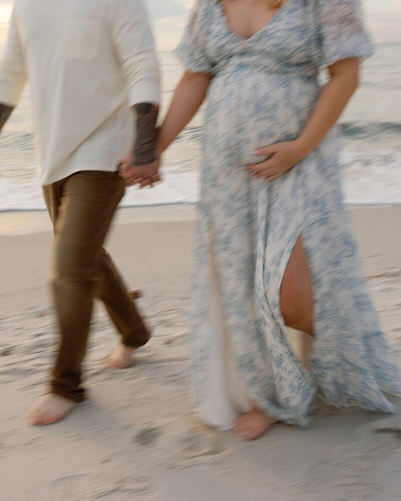 expecting parents holding hands, taken by one of the best naples family photographers
