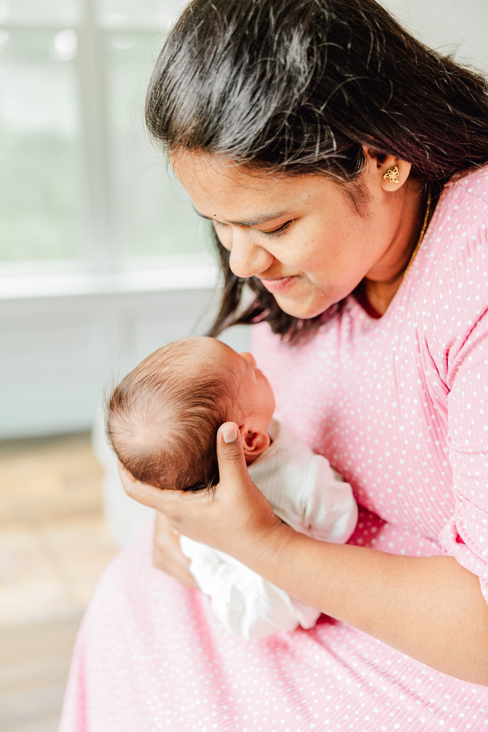 Mom pulls her newborn boy up to her face