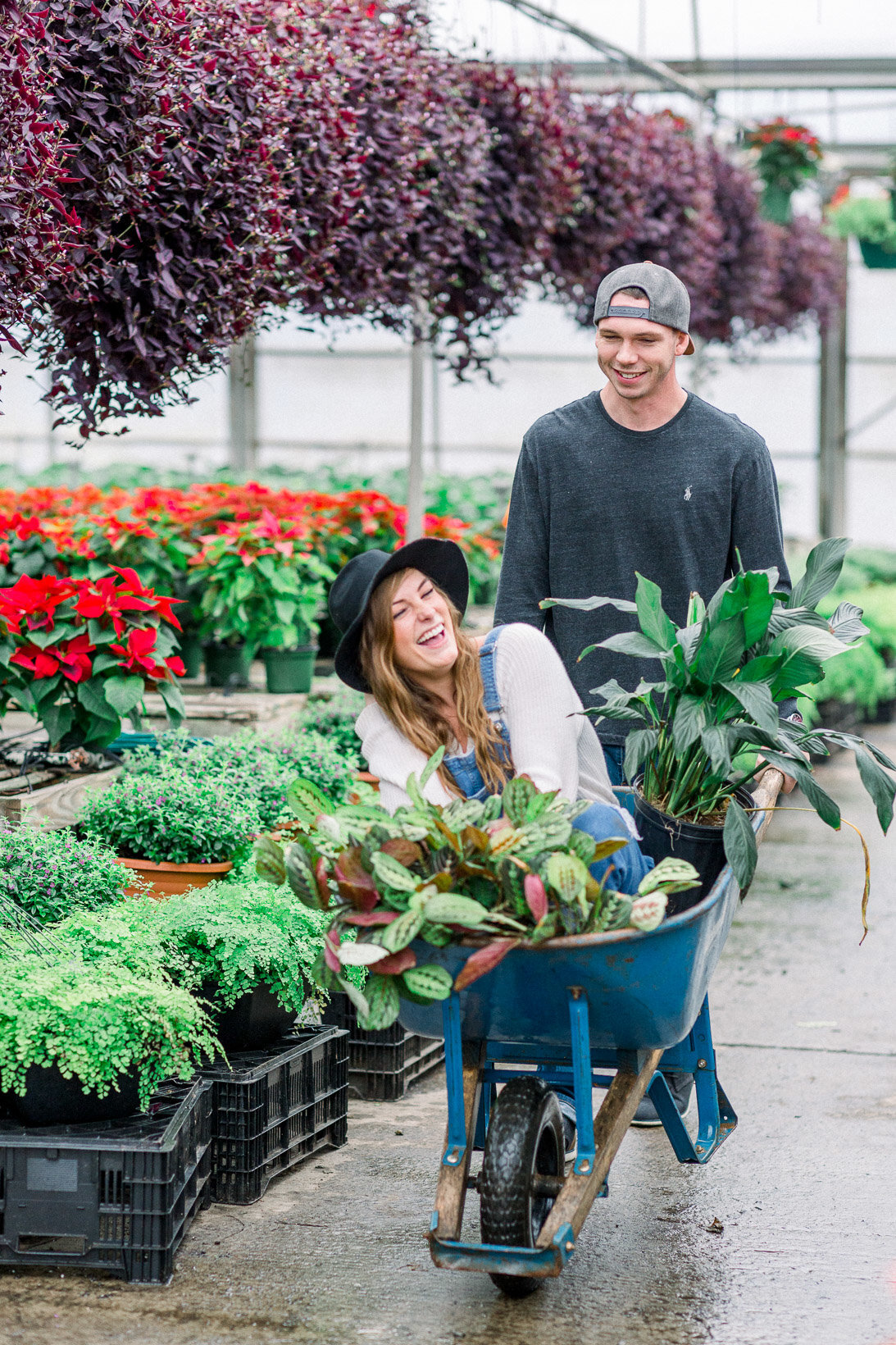Couple having fun and laughing in the greenhouse captured by Staci Addison Photography