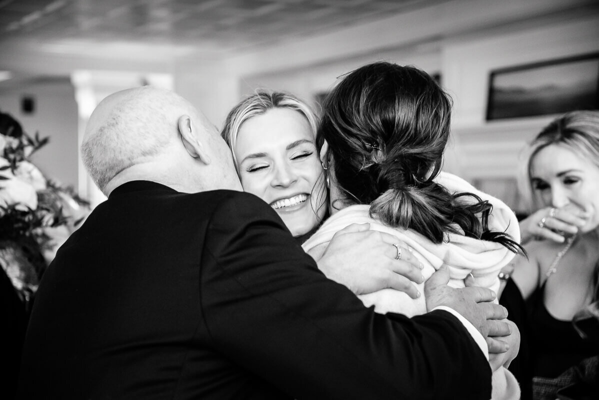 A family hugs and smiles after the ceremony during an Equinox Resort wedding in Manchester, Vermont, captured by Eaton Photo