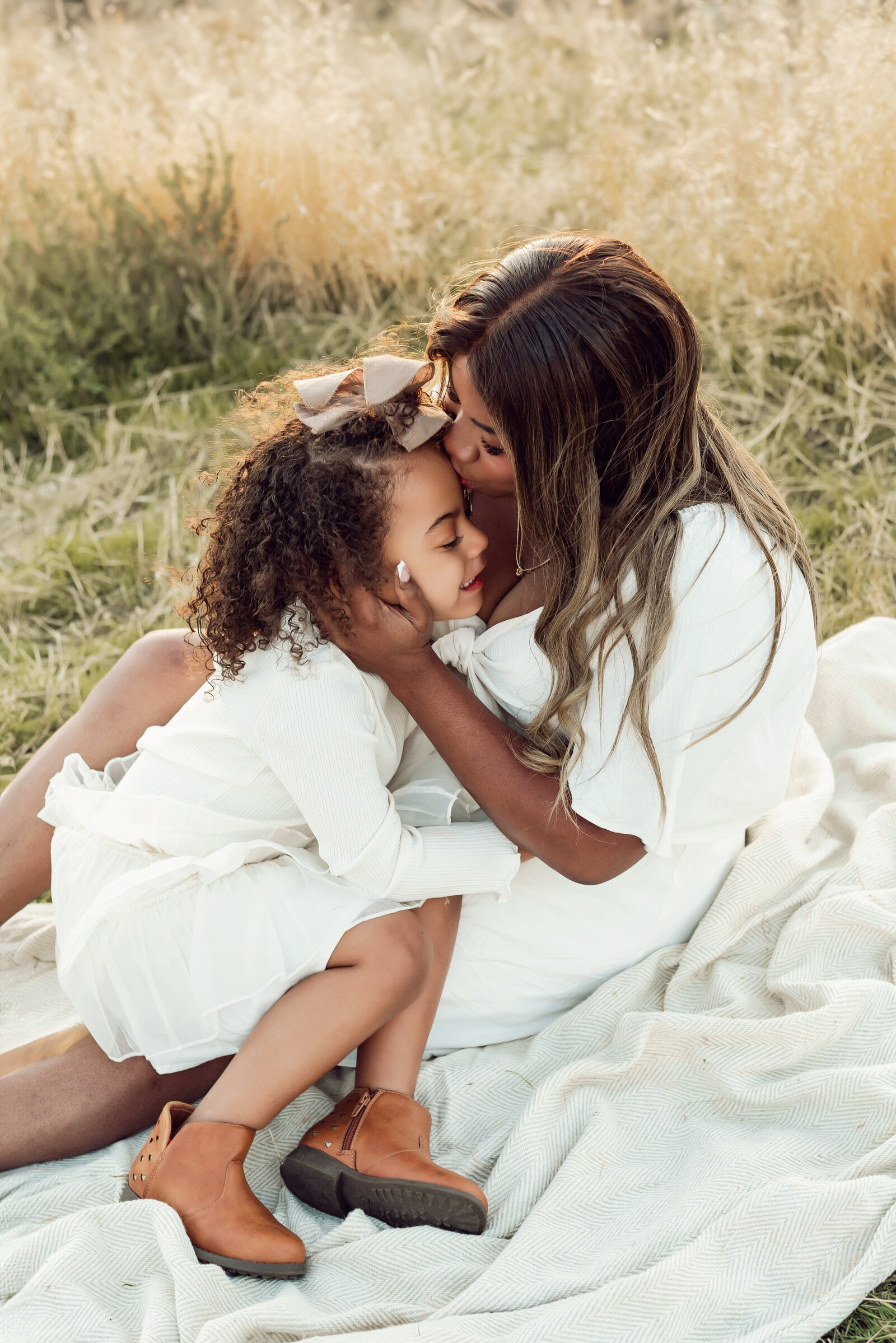 mom and daughter boho setup outdoors in dry grass