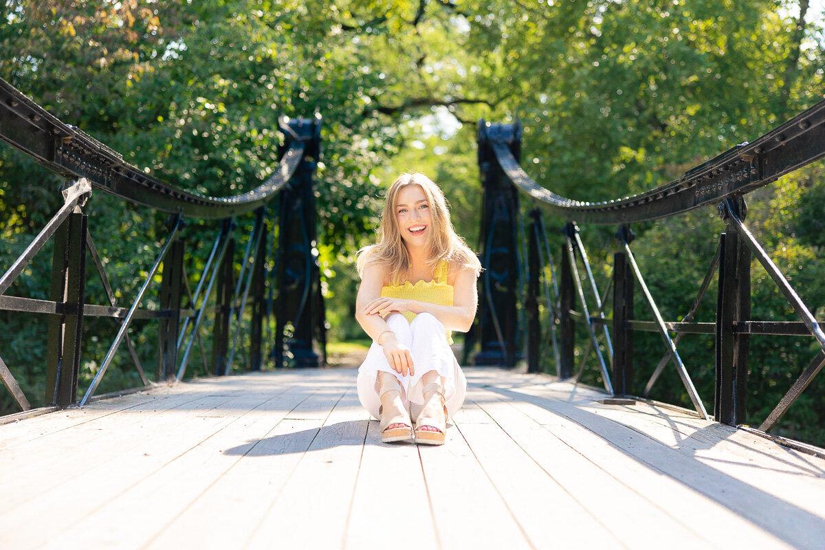 senior sitting in the center of the victorian bridge in forest park in st. louis