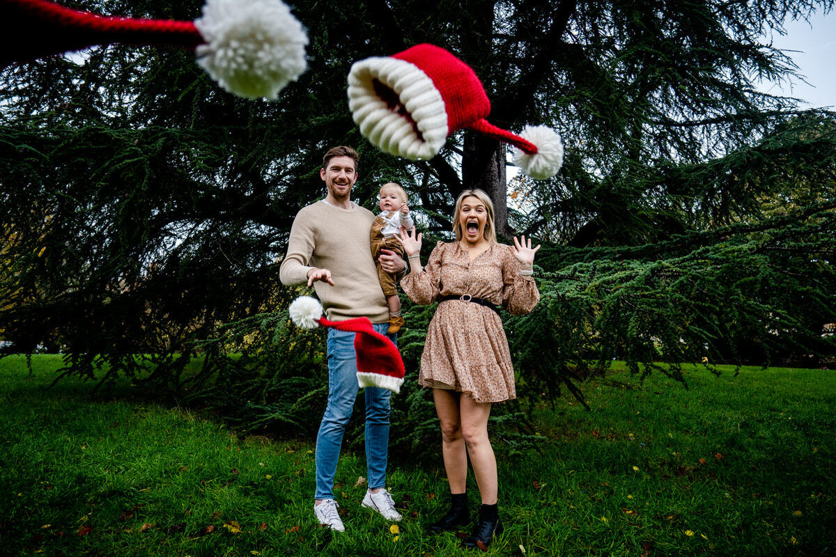 family photograph of them throwing santa hats tpwards the camera