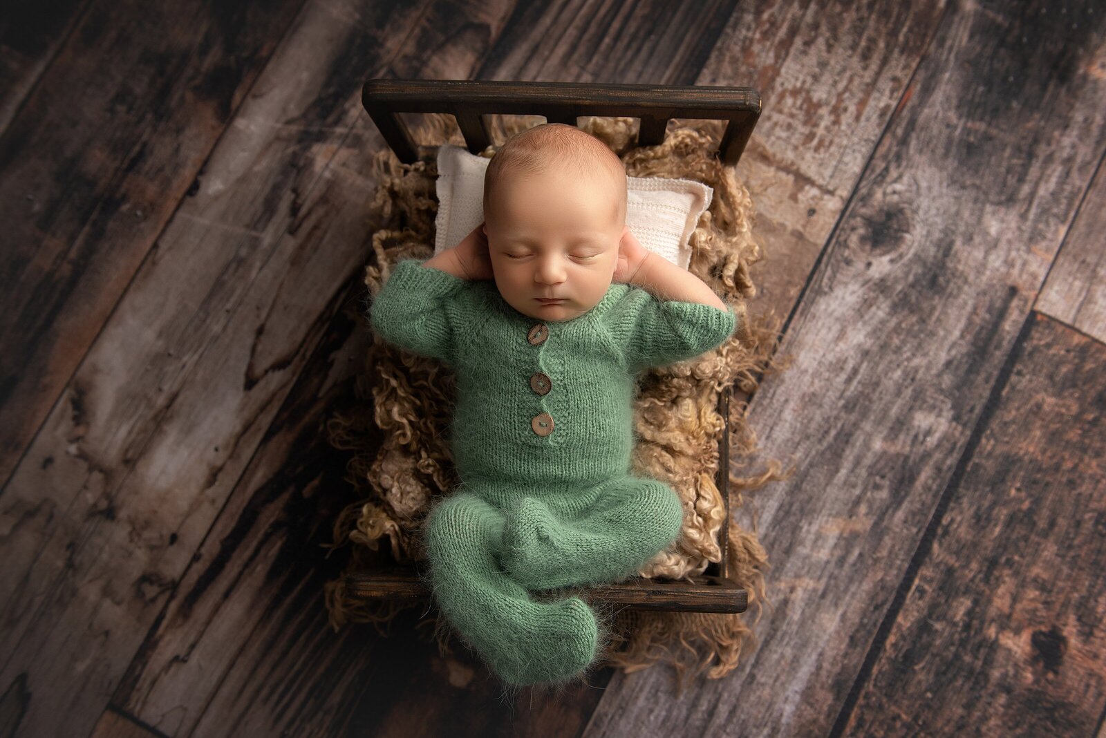 newborn in green outfit