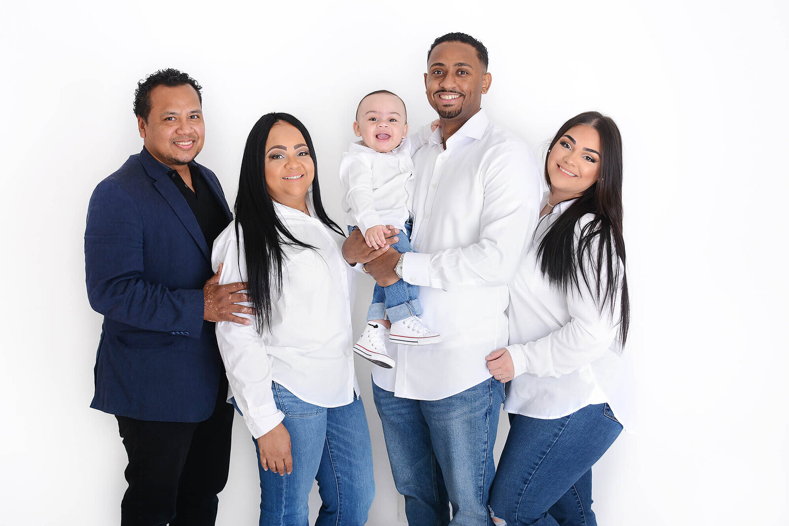 an extended family pose together for a photo in a studio in houston