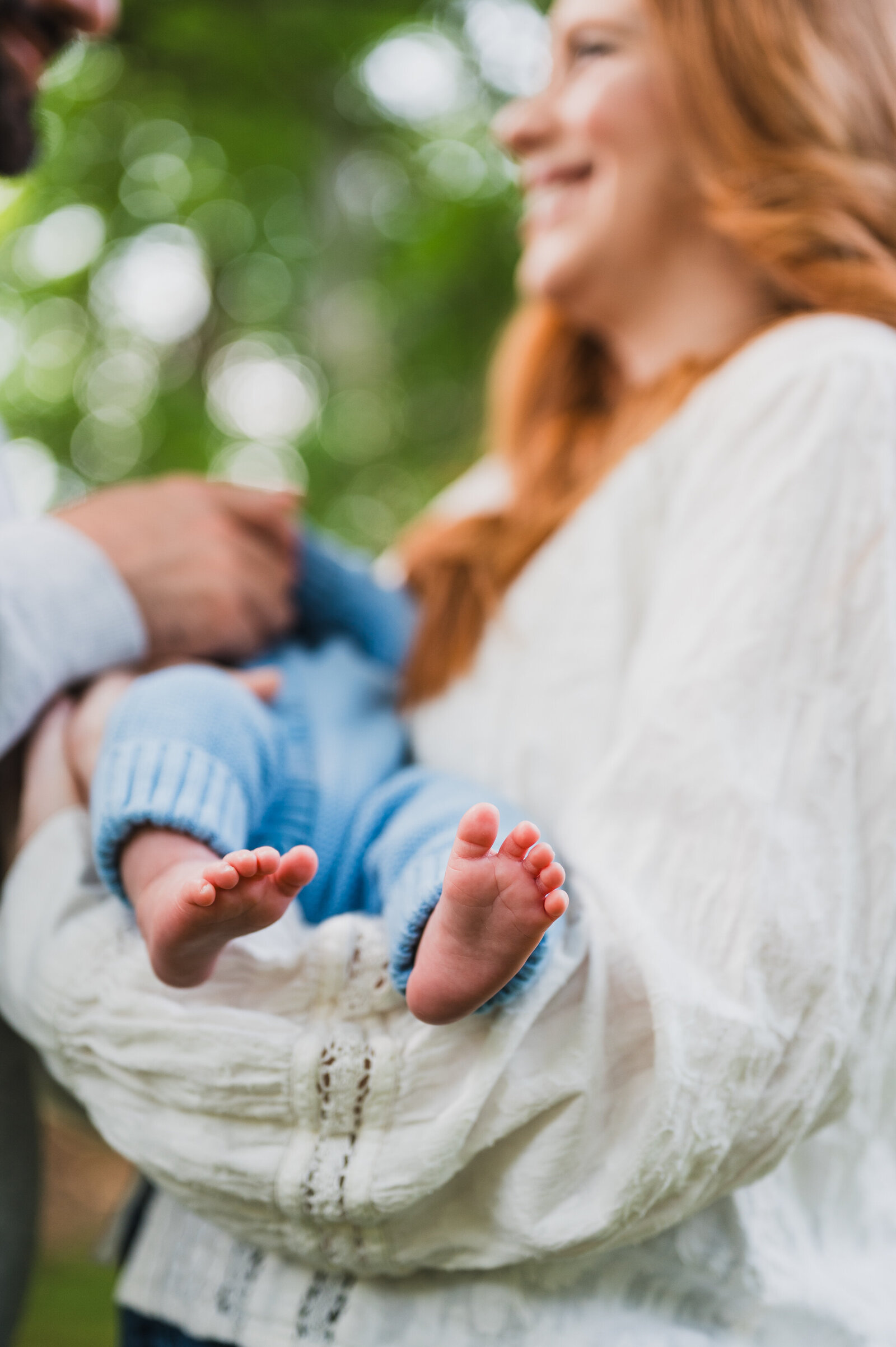 Parents holding their newborn outside during a documentary family photo session