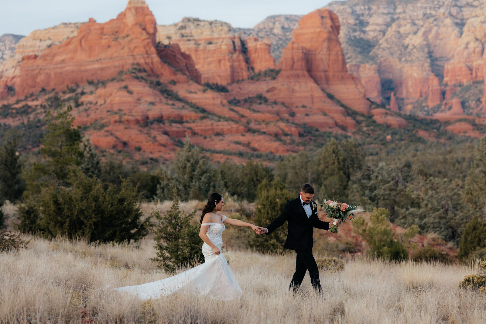 Groom leading bride in field in Sedona, Arizona