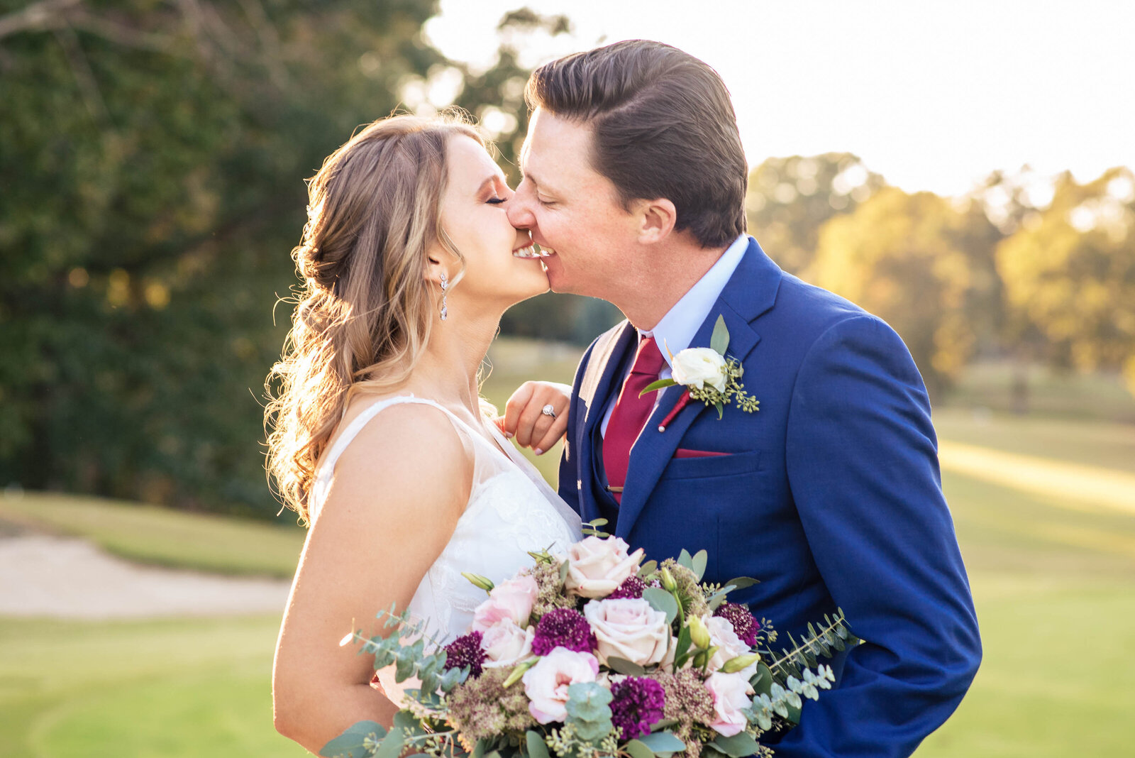 Close-up-photograph-of-bride-and-groom-smiling-just-before-they-kiss-with-the-golf-course-of-Pine-Island-Country-Club
