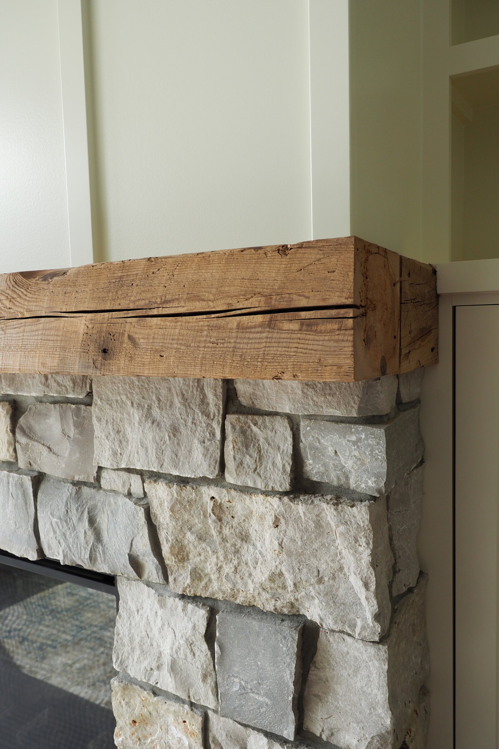Close up picture of a wood mantle and stone fireplace surround.
