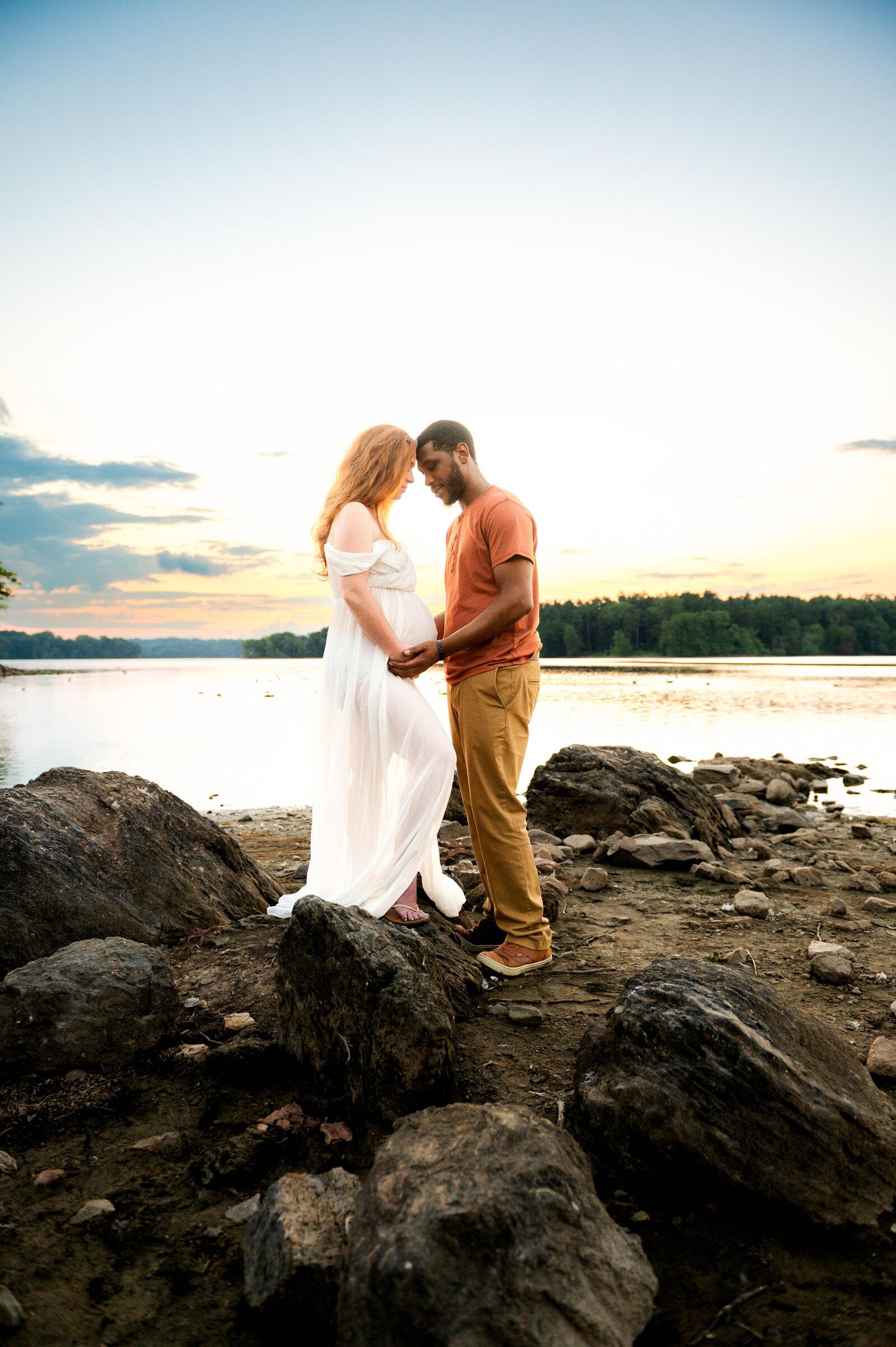 couple on the rocks during a maternity photoshoot