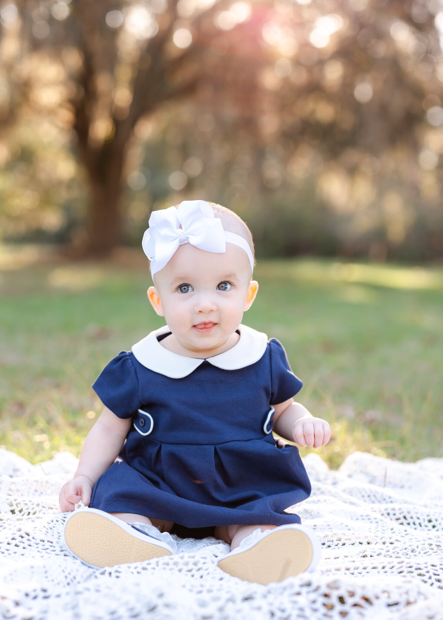 Little girl in a navy dress smiling at the camera during her family photoshoot in Savannah, Ga