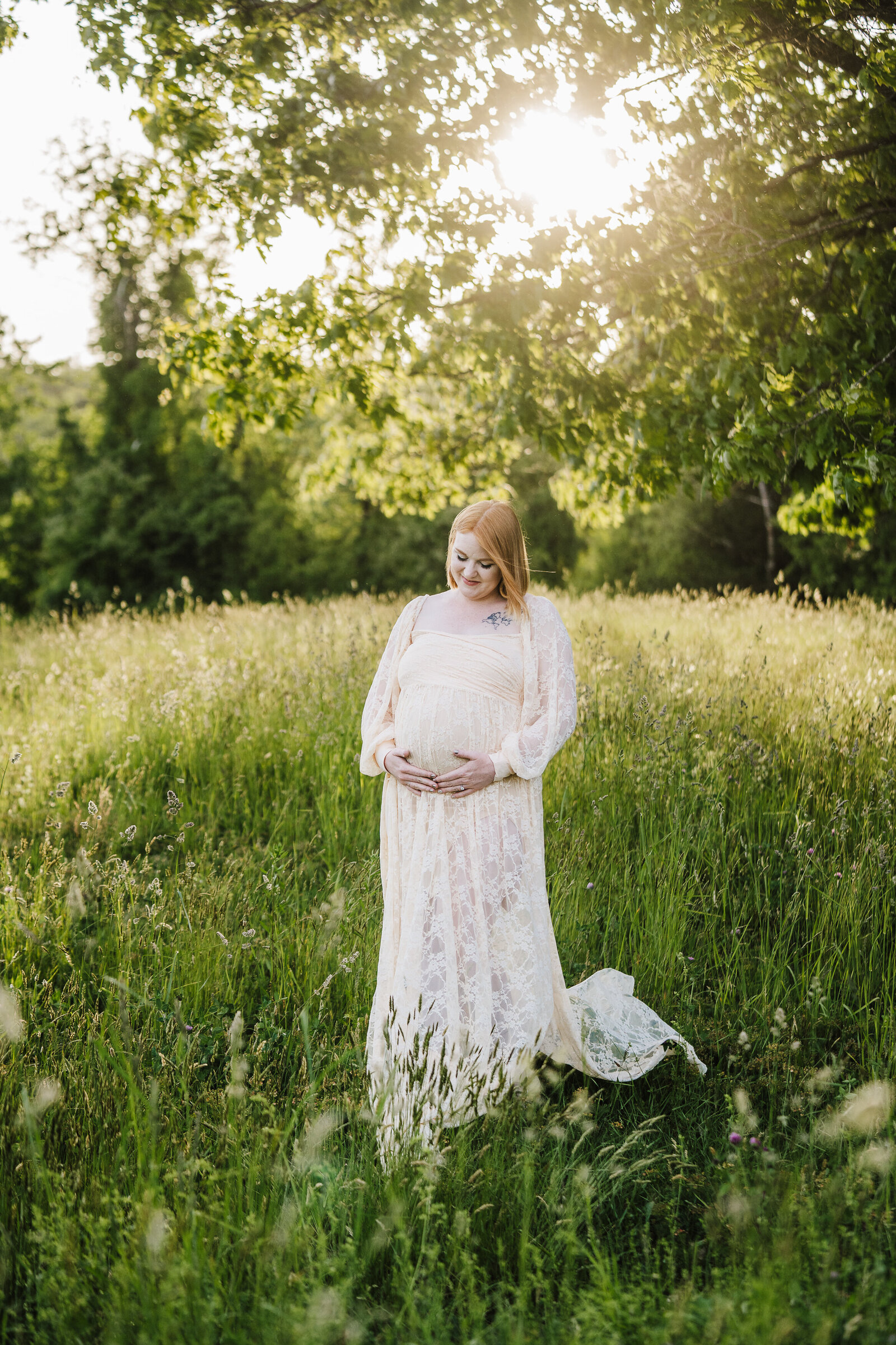 pregnant woman in lace dress in green field