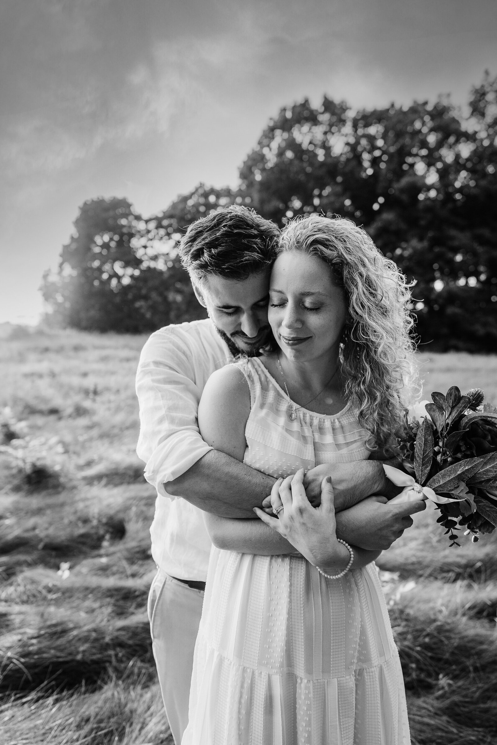 black and white image of bride and groom hugging