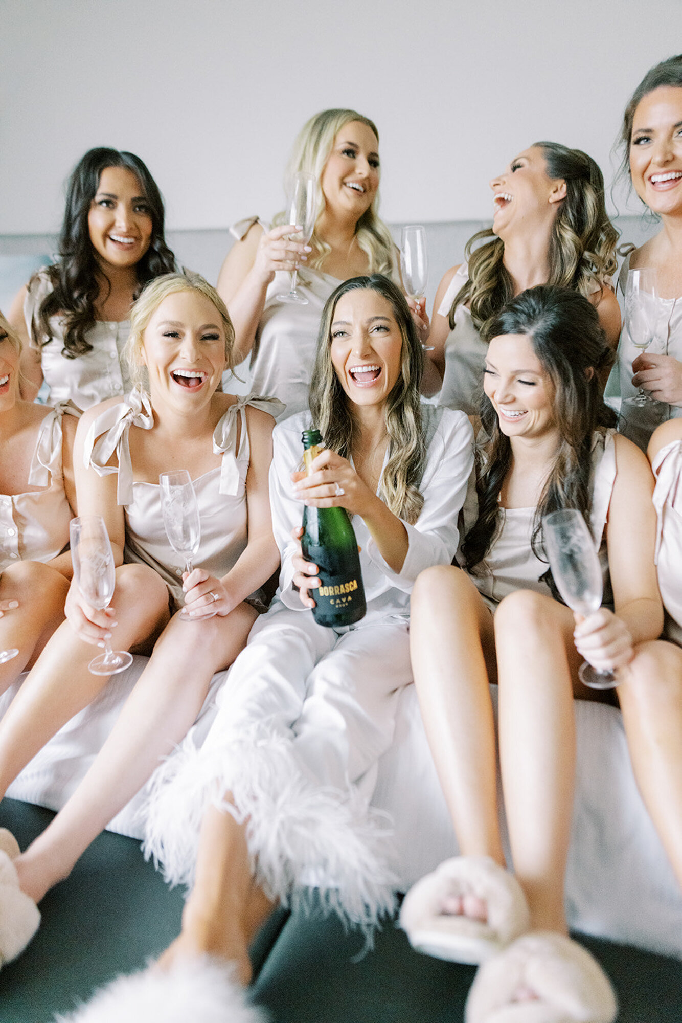 bridal party popping champagne and wearing slippers