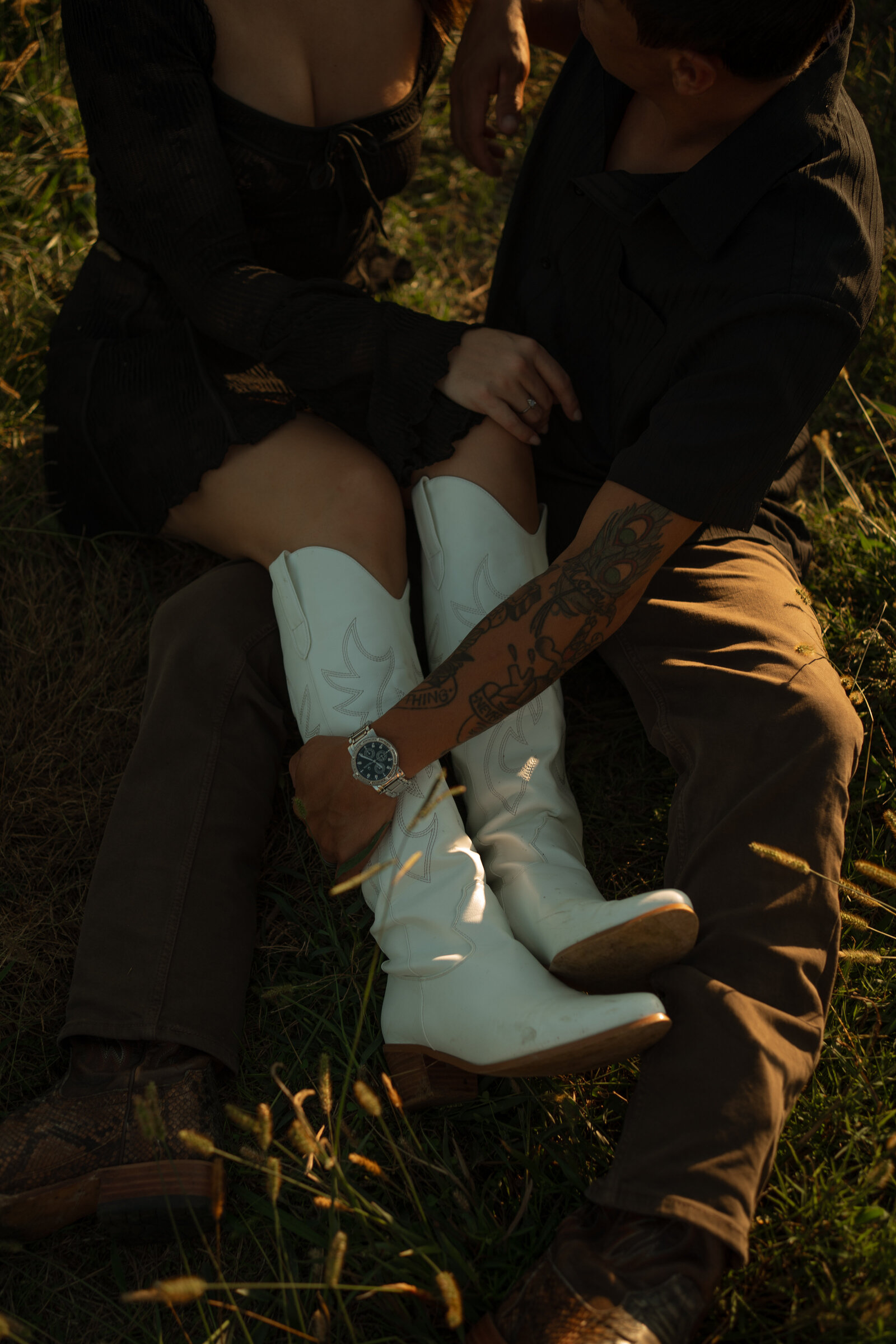 A married couple sitting in a field snuggling during golden hour in Tennessee.