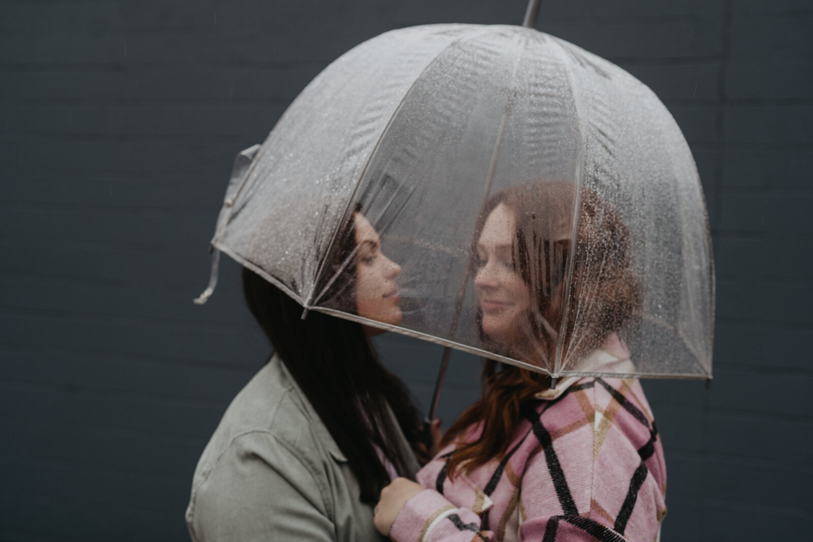 Couple embraces under umbrella in the rain