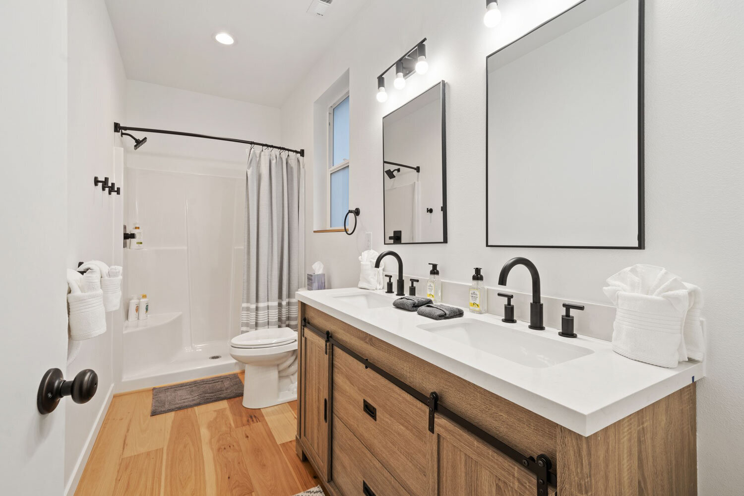 White double vanity bathroom with mirrors and bright lighting