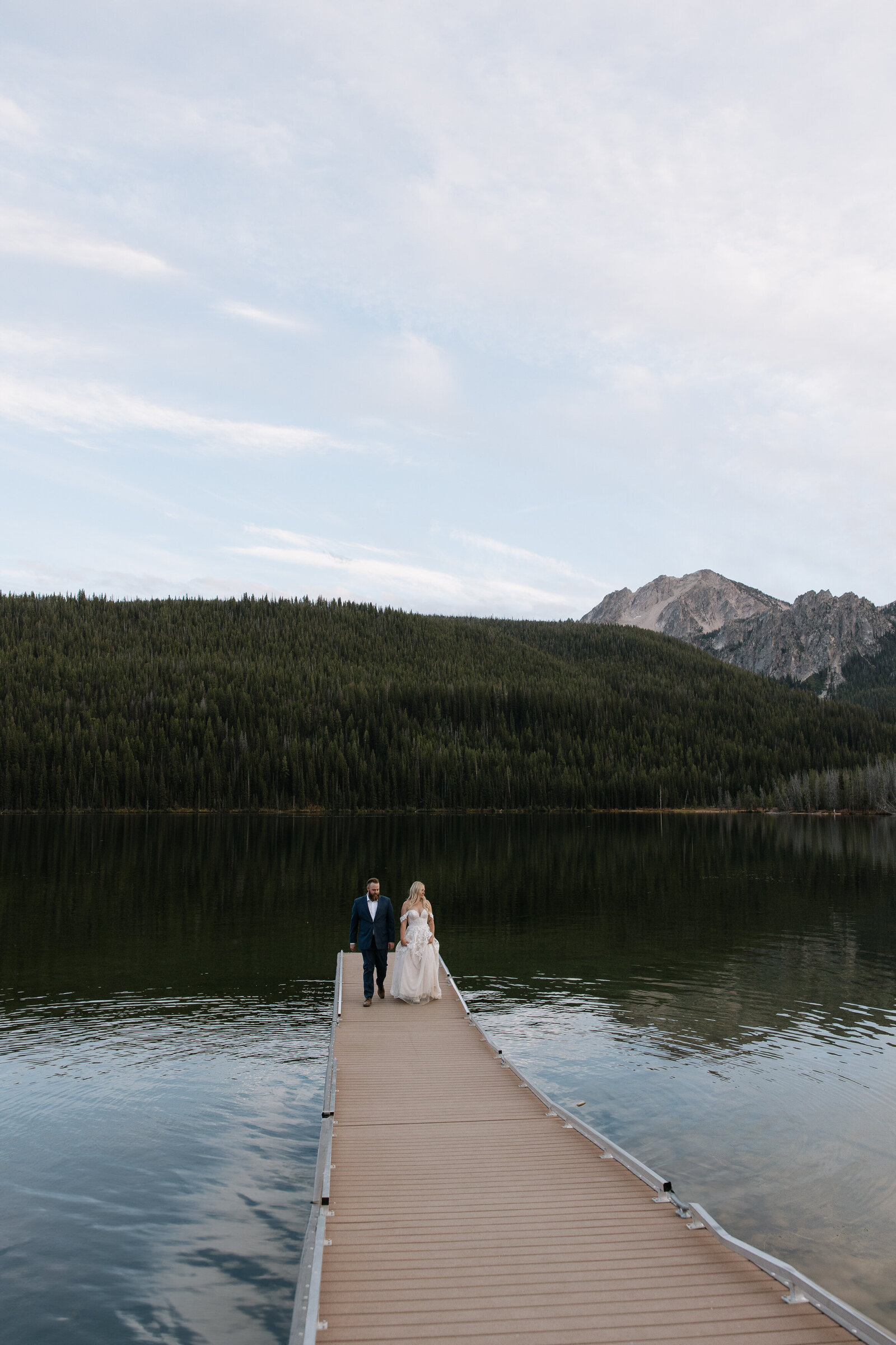 Bride and groom posing on dock during Idaho elopement at Stanley Lake
