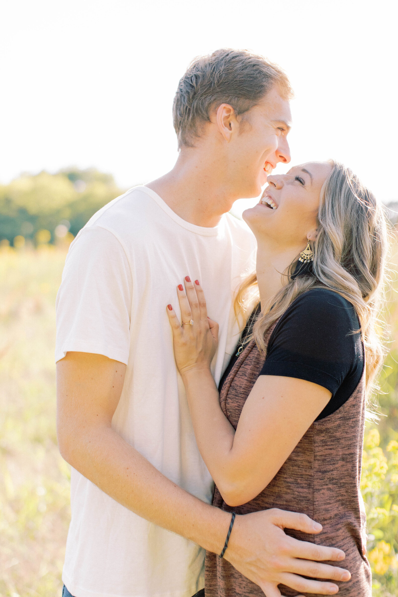 Couple laugh together at engagement shoot at Shawnee Mission Park